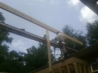Carpenter setting a ridge beam over a new addition frame — Ice Dam Removal by Roofing Brothers in Branson