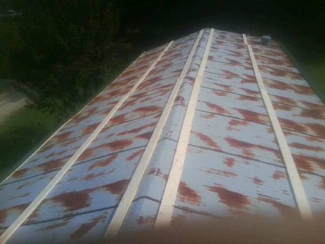 Rusted metal roof panels with new wood purlins before replacement — Storm Damage Roof Repair in Branson by Roofing Brothers